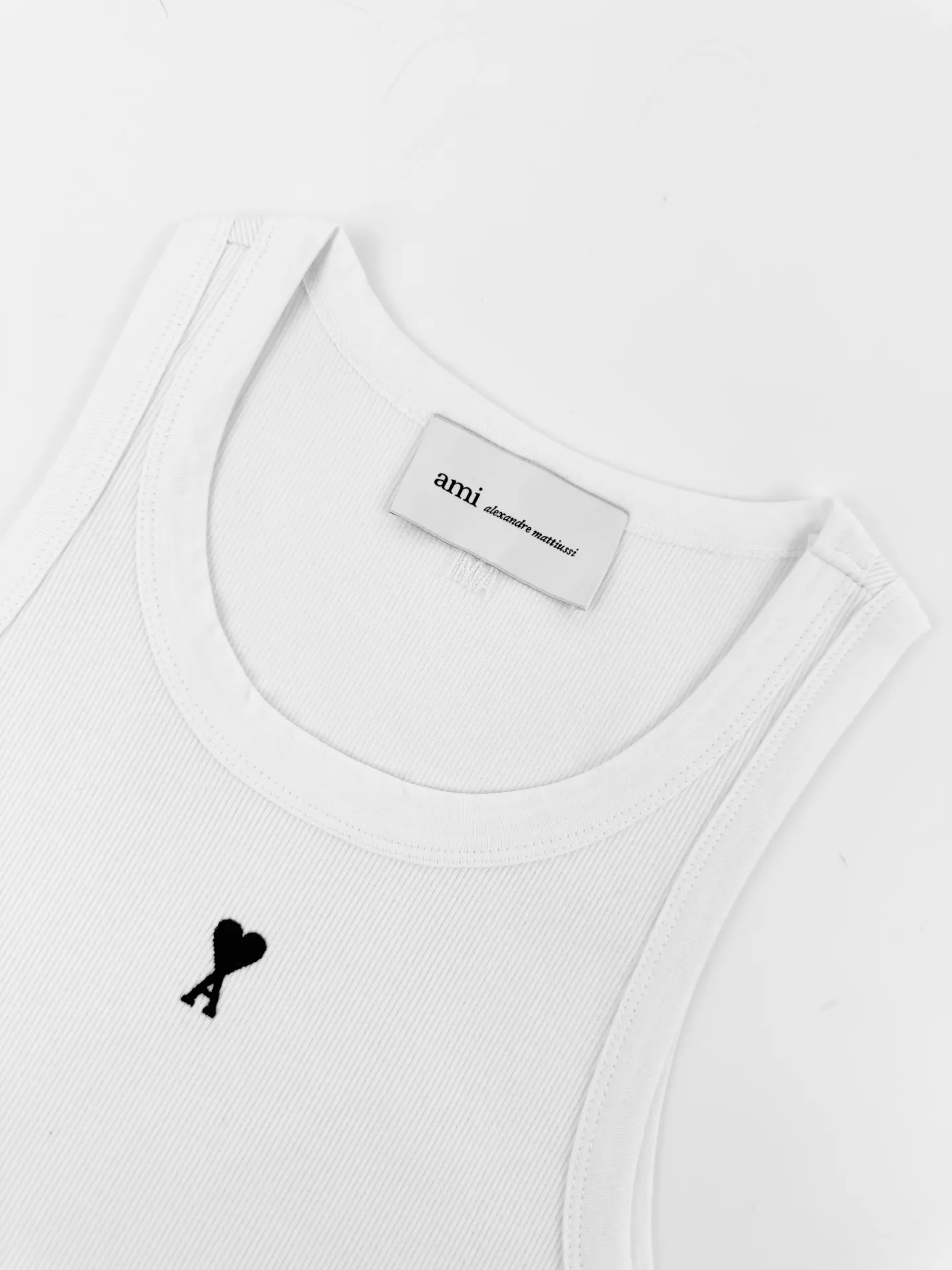 Logo embroidered vest Customized luxurious and soft plain cotton, cloud-like and skin-friendly, refreshing Breathable to pure white tones embody French elegance, showing a luxurious style when relaxed. The love logo on the front is lightly embroidered in black. The back collar has ami embroidery with dark engraved texture. French attitude on both sides. Minimalistic and quality. Hidden charm inside. Wear it casually alone. Versatile is elegant and effortless. Process 1: Use imported machine embroidery technology. Use advanced computer control systems and precision mechanical components to achieve Ami logo and letter embroidery operations with high precision and smooth and delicate lines. Process 2: The fabrics have been fermented and washed for a better hand feel. Not easy to deform, not easy to shrink, not easy to fade, and maintain long-term beauty. Accessories: Customized 1:1 Ami trademark. Version: Fitted version. Size: S M L XL. Style number: AA 603.
